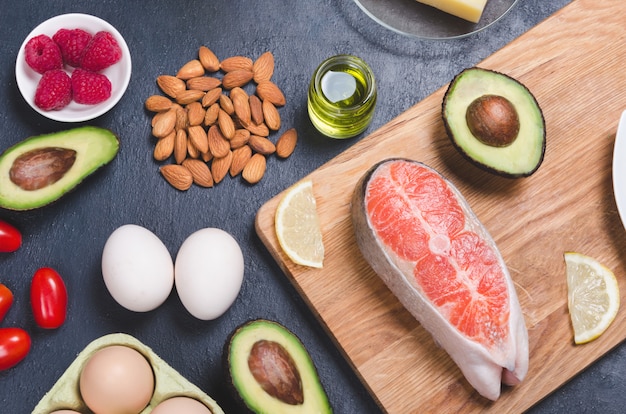 Comida sana baja en carbohidratos sobre fondo negro. Concepto de dieta cetogénica