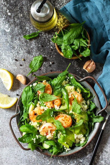 Comida sana Dieta cena Ensalada de cuscús con rúcula, aguacate y camarones a la parrilla Vista superior