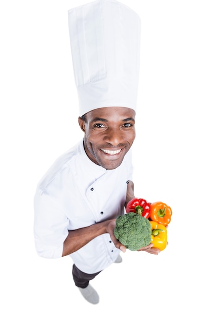 la comida sana está en sus manos. Vista superior del alegre joven chef africano en uniforme blanco