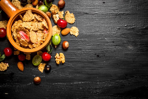 Comida sana. Muesli con frutos del bosque. Sobre una mesa de madera negra.