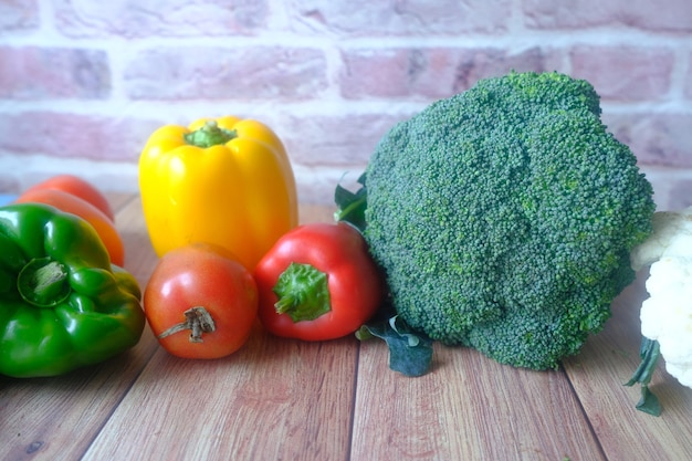 Comida sana con papel, coliflor brocoli en escritorio de madera.