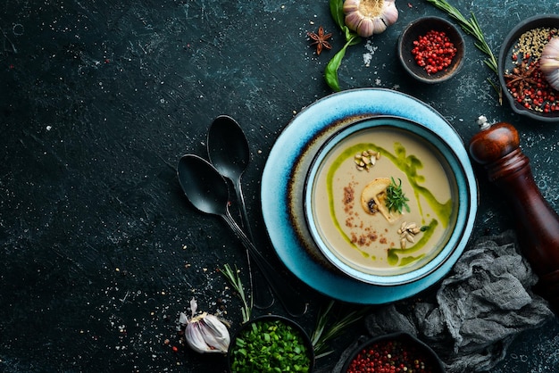 Comida sana Sopa de crema de champiñones en un plato sobre un fondo de piedra negra Vista superior Estilo rústico