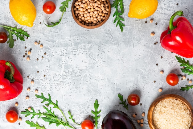 Comida sana. Verduras, limón y garbanzos en una mesa de hormigón, vista superior. Concepto de comida vegetariana y vegana, espacio de copia. Alimentos crudos para cocinar cocina mediterránea.