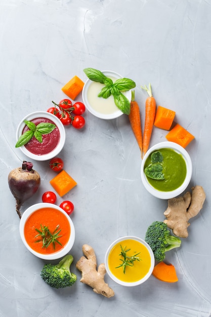 Comida saudável, conceito de alimentação limpa. variedade de sopas cremosas de vegetais coloridos sazonais de outono com ingredientes. abóbora, brócolis, cenoura, beterraba, batata, espinafre de tomate. postura plana, copie o espaço