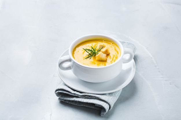 Foto comida saudável, conceito de alimentação limpa. vegetais de outono picantes sazonais abóbora cremosa e sopa de cenoura com ingredientes em uma mesa. copie o fundo do espaço