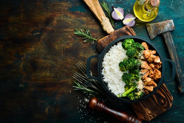 Comida saudável Frango com molho teriyaki arroz cozido e brócolis em uma panela preta Estilo rústico Vista superior