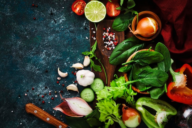 Comida saudável fresca cozinhando ou salada fazendo ingredientes em fundo escuro com placa de madeira rústica Dieta ou conceito de comida vegetariana Espaço de cópia de vista superior