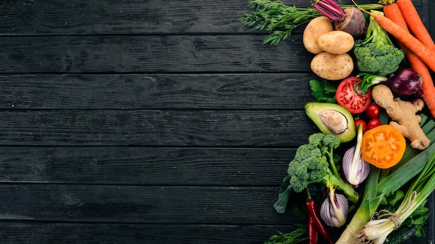 Comida saudável Legumes e frutas Em um fundo preto de madeira Vista superior Copie o espaço