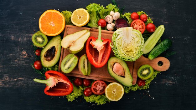 Comida saudável Legumes e frutas Em um fundo preto de madeira Vista superior Copie o espaço