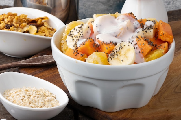 Foto comida saudável salada de frutas com semente de chia e iogurte em uma tigela foco seletivo