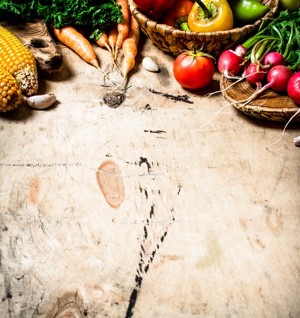 Comida saudável. vegetais organícos. legumes frescos com ervas. em fundo de madeira.