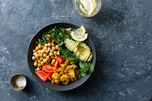 Comida saudável vegetariana com grão de bico, tomate, abacate e espinafre