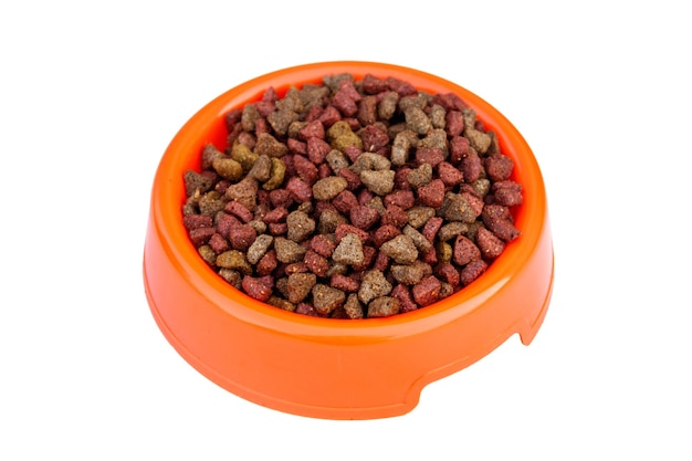 Comida seca para gatos en tazón de fuente naranja. Alimentos para mascotas aislado sobre fondo blanco. Vista superior