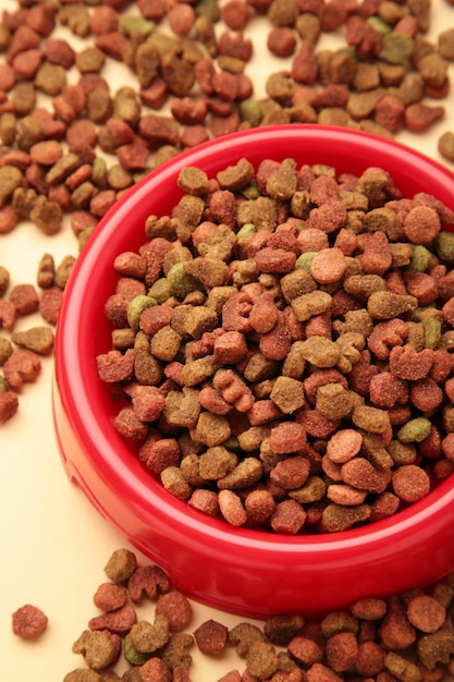 Comida seca para mascotas en tazón rojo sobre fondo claro Vista superior