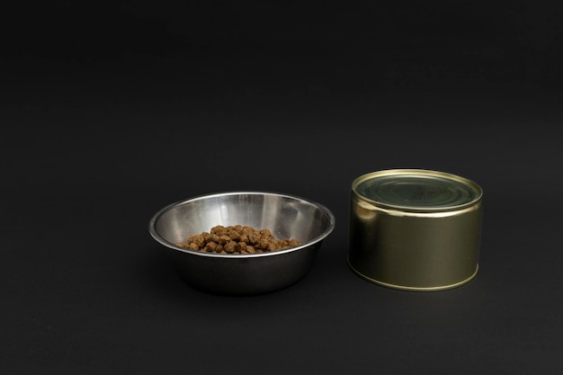 Comida seca para perros en una placa de aluminio sobre una comida para perros de fondo negro