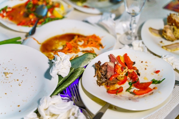 La comida sobrante y los platos sucios en la mesa del restaurante. Sobras de sobras después de la fiesta.