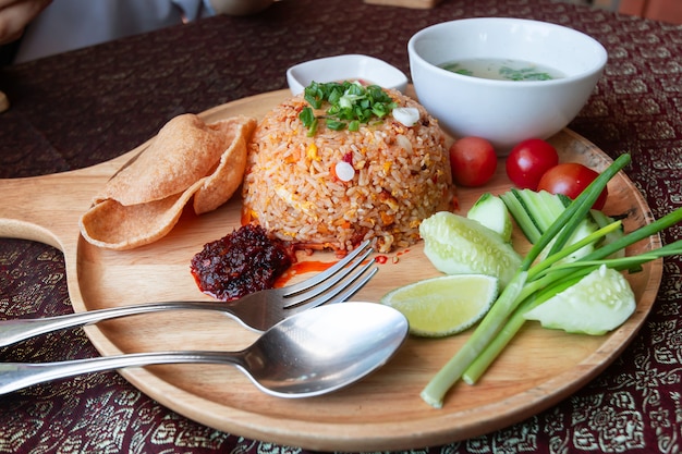 Comida tailandesa de arroz frito en una tabla de cortar de madera