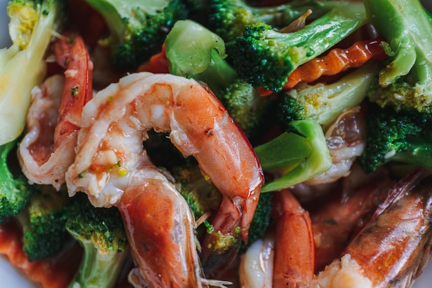 Comida tailandesa brócoli salteado con camarones en plato blanco