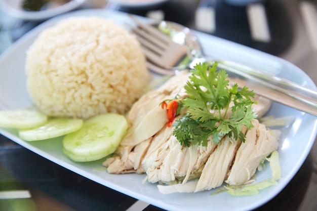 Comida tailandesa gourmet pollo al vapor con arroz, khao mun kai en fondo de madera