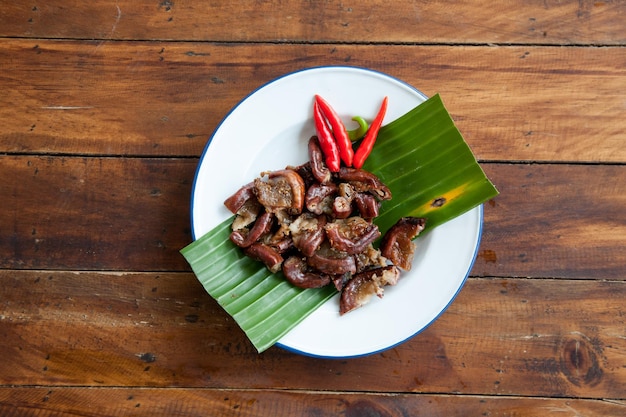Comida tailandesa intestino de cerdo a la parrilla en la vista superior de la mesa de madera