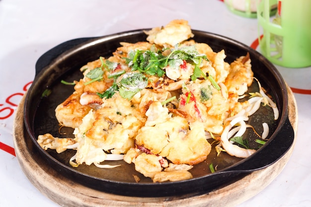 Comida tailandesa, panqueca de mexilhão frito na panela quente