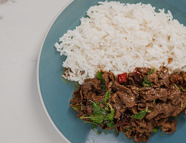 Comida tailandesa: salteado con carne de res y albahaca en un plato verde concepto de comida tailandesa. Comida callejera tailandesa