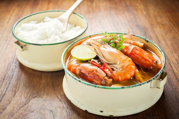 Comida tailandesa, sopa picante de camarão rio ou tom yum goong na mesa de madeira