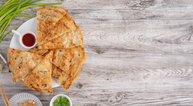 Comida taiwanesa deliciosas tortitas de pastel de cebolleta escamosa sobre fondo de mesa de madera brillante bocadillo tradicional en la vista superior de Taiwán