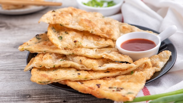 Comida taiwanesa - deliciosos panqueques de pastel de cebolleta sobre fondo de mesa de madera brillante