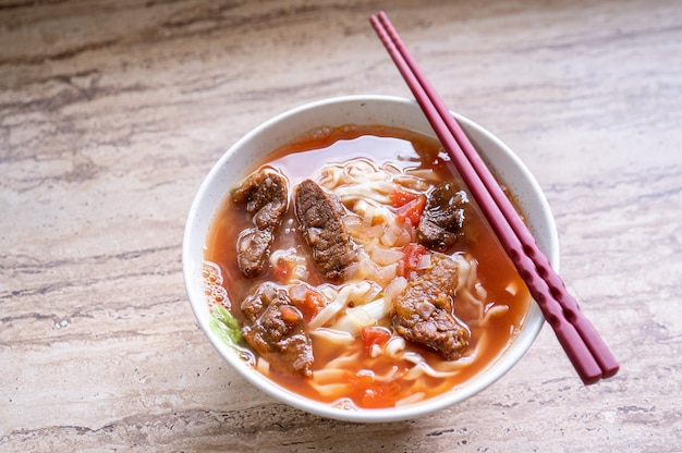 Comida taiwanesa - Ramen de macarrão de carne com caldo de molho de tomate em uma tigela