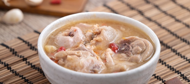 Comida taiwanesa - sopa de pollo con ajo deliciosa casera en un recipiente sobre fondo de mesa de madera oscura.