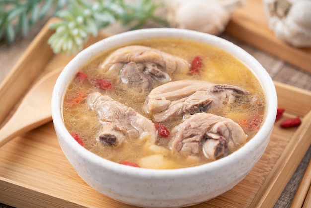 Comida taiwanesa - sopa de pollo con ajo deliciosa casera en un recipiente sobre fondo de mesa de madera oscura.