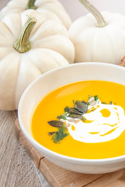 Comida de temporada Sopas de calabaza. Sopa decorada con salsa de crema y semillas de calabaza.