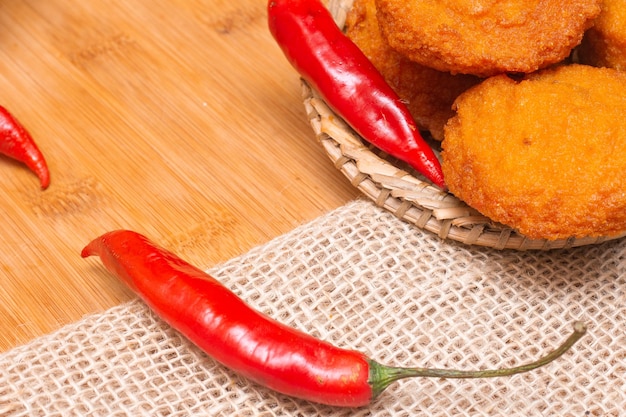 Foto comida típica de bahía llamada acaraje rodeada de pimientos rojos