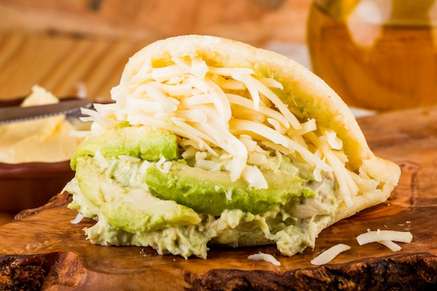 Comida típica latinoamericana, arepa para desayunar con queso, aguacate y pollo