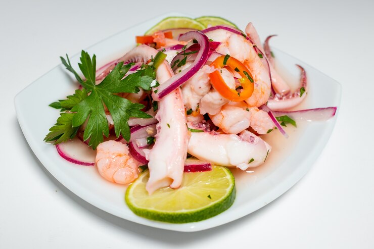 Foto comida típica peruana, ceviche de lula, camarão e peixe branco com cebola roxa e um bom leite de tigre.