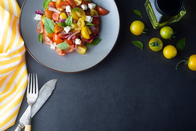 Comida, tomates cherry y ensalada de albahaca en un plato. Comida saludable de verano.