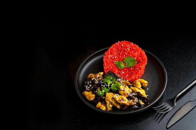 Foto comida tradicional asiana en un plato sobre un fondo negro