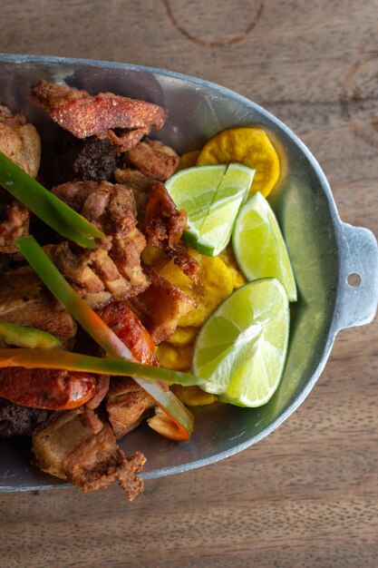 Comida tradicional colombiana frita ou picada composta por almôndegas, batata de frango e torresmo