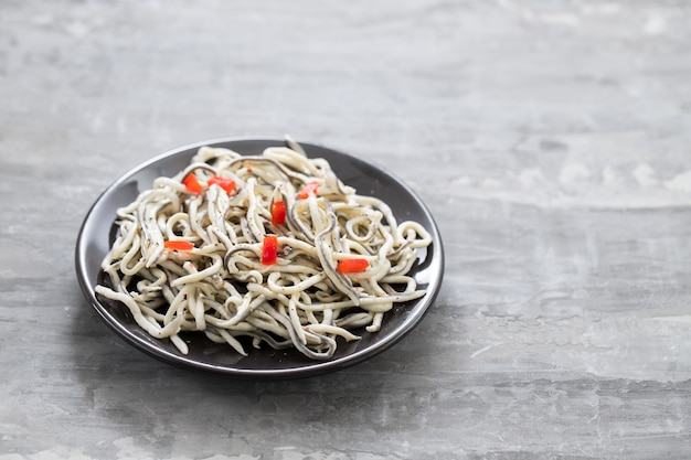 Comida tradicional espanhola. Gulas com óleo na chapa branca.