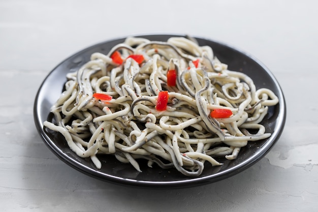 Comida tradicional espanhola. Gulas com óleo na chapa branca.