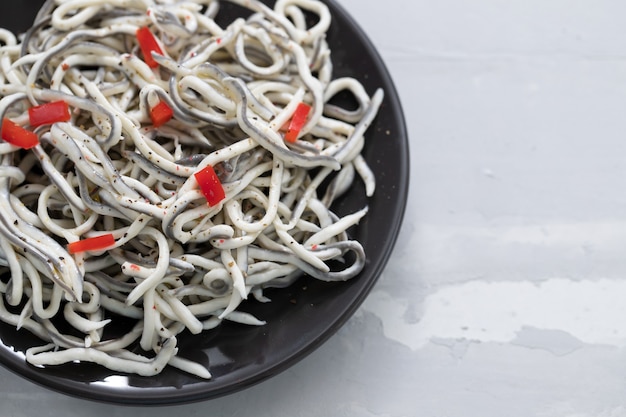 Comida tradicional espanhola. Gulas com óleo na chapa branca.