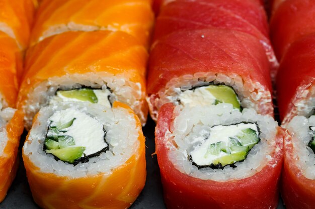 Comida tradicional japonesa. conjunto de rolos de sushi com abacate de salmão fresco e cream cheese e molho de soja