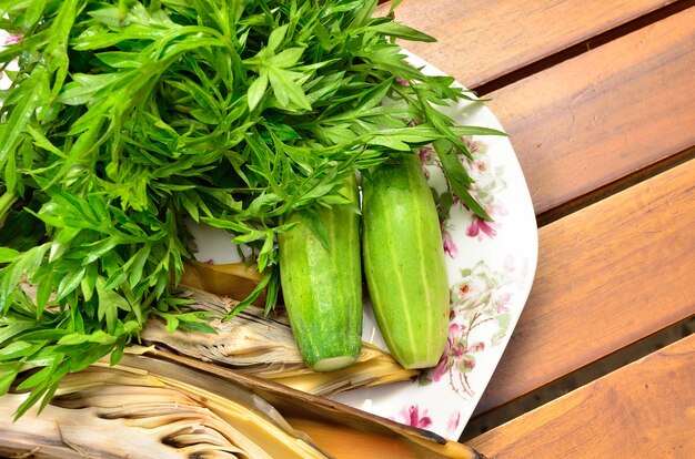 Comida tradicional malaya. Cosmos caudatus con flor de plátano comestible y pepino sobre plancha de madera