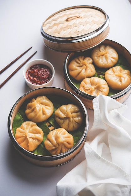 Comida tradicional momos de bola de masa hervida de Nepal servida con chutney de tomate sobre un fondo cambiante. Enfoque selectivo