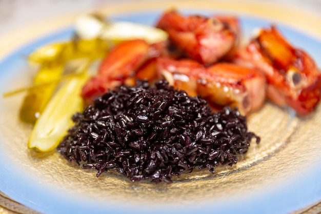 Comida tradicional rústica brasileña, arroz negro, costillas de cerdo ahumadas y pepinillos