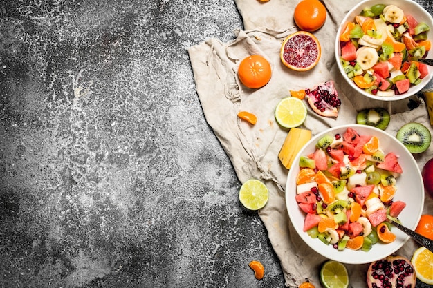 Comida tropical Una ensalada de frutas tropicales sobre fondo rústico