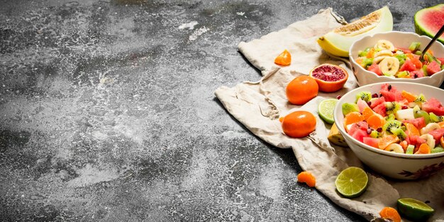 Comida tropical Salada de frutas tropicais em fundo rústico