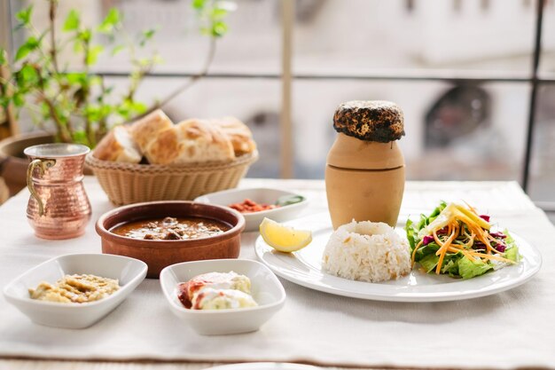 Comida turca tradicional da Capadócia em cerâmica, kebab irritado na cidade de Goreme servido na mesa com salada e arroz.