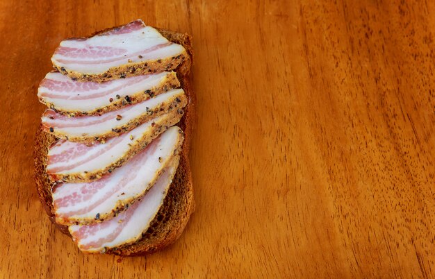 Comida ucraniana Apetitosas rebanadas de salo se encuentran en una mesa de la cocina oscura